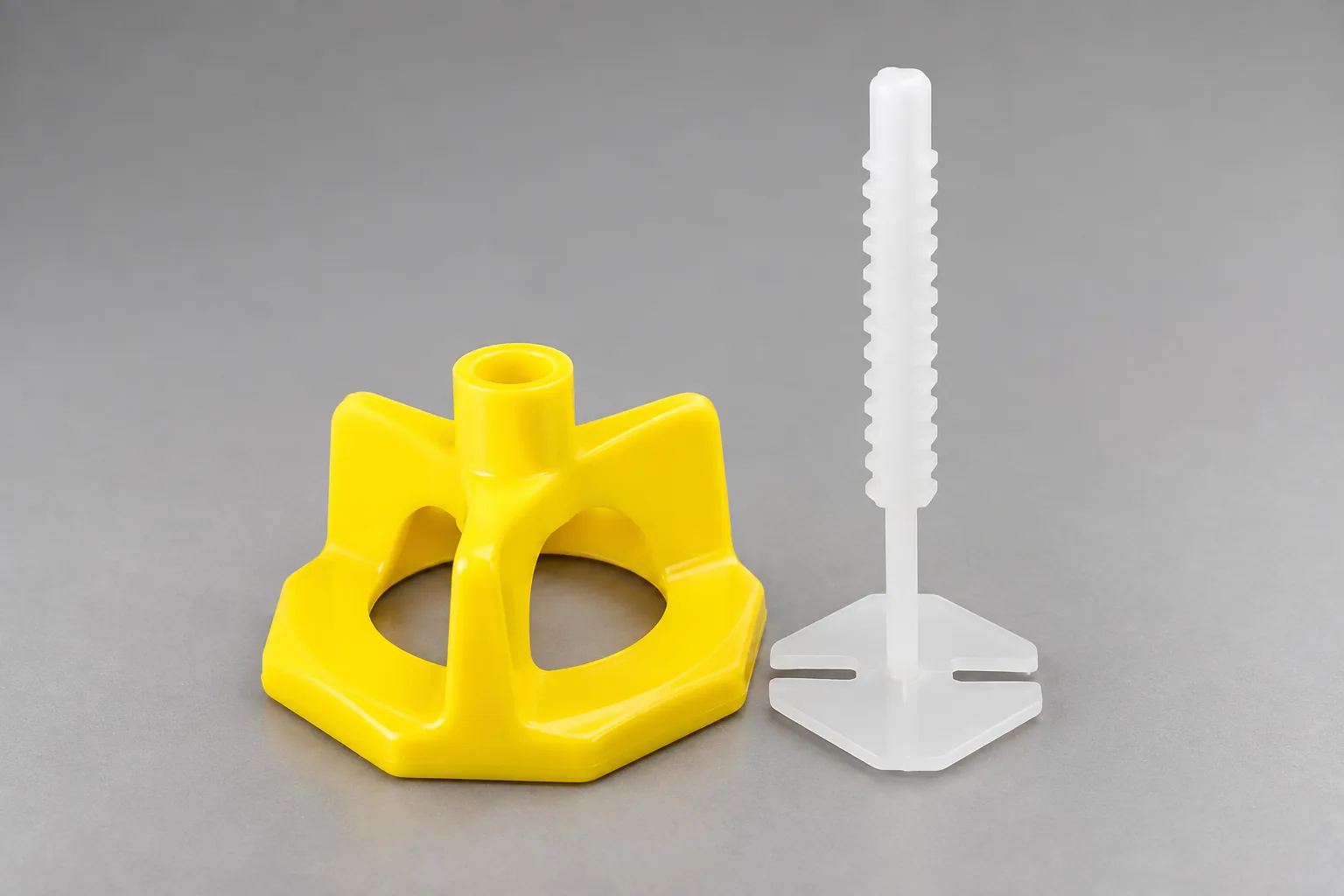 Yellow octagonal spinner leveling cap beside a white ribbed pin